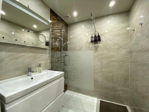 La salle de bains blanche est pourvue d'un lavabo et d'une douche. dans l'établissement Gemütliche Wohnung in Ottakring, à Vienne