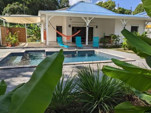 uma casa com piscina com baloiço em Coquette villa avec piscine proche des plages em Sans Pareil
