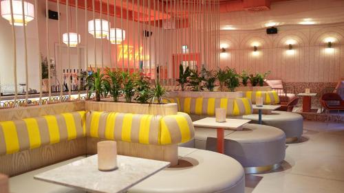 a restaurant with yellow and white couches and tables at Beach Apartments Heiligenhafen in Heiligenhafen