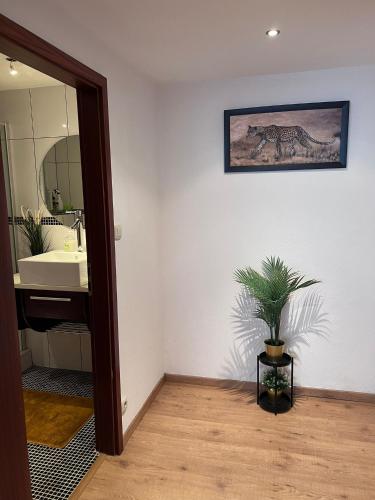 a bathroom with a sink and a potted plant at Cozy Flat near Maastricht Heerlen Aachen in Übach-Palenberg