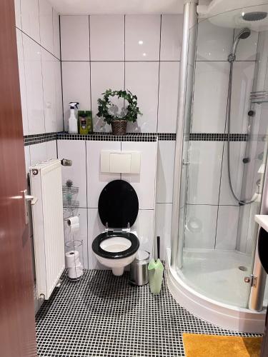 a bathroom with a black toilet and a shower at Cozy Flat near Maastricht Heerlen Aachen in Übach-Palenberg