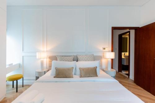 LUXFolio Retreats - Amazing Marina Location في دبي: غرفة نوم بسرير ابيض كبير مع وسادتين
