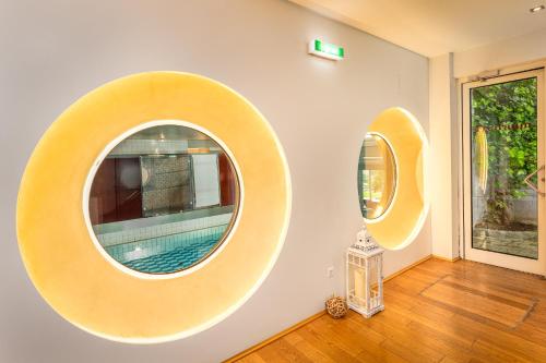 two mirrors on the wall of a room with a pool at Hotel Ramsauhof Pool & Wellness Breakfast & Light Dinner Buffet in Ramsau am Dachstein