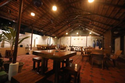 un restaurante con mesas de madera y sillas en una habitación en Hotel Holiday Home en Kovalam