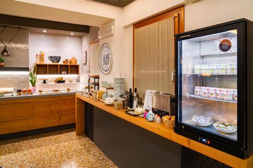 una cucina con un bancone con un grande frigorifero di Hotel Alla Corte SPA & Wellness Relax a Bassano del Grappa