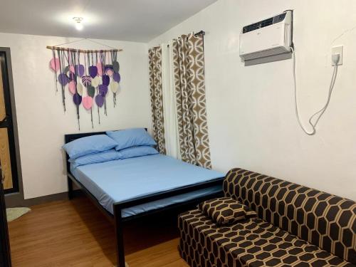 Habitación pequeña con cama y sofá en Capaclan Centro Private Room en Romblon