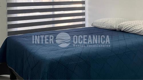 a bed with a blue comforter on top of it at Lujo en Crystal Lagoons: Paraíso para la familia. in Mazatlán