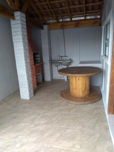 un gran patio con una mesa de madera en una habitación en Casa e conforto en Itapoa