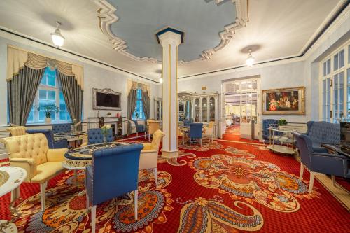 a large room with blue chairs and a red rug at Häcker's Hotel in Bad Ems