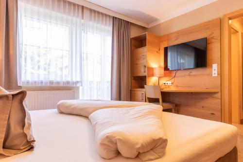 a hotel room with a bed and a television at Hotel Castel - pure Lebensfreude in Serfaus