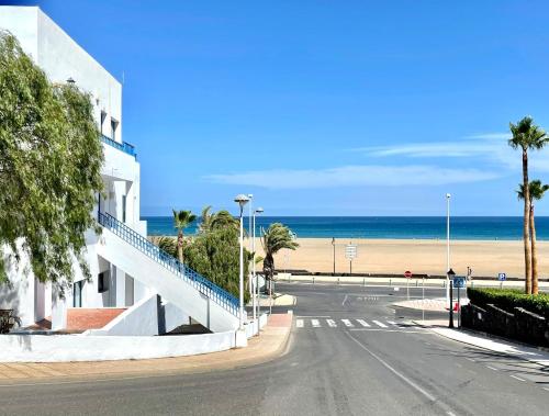 una calle vacía junto a una playa con palmeras en One Bedroom with a pool, near Playa Chica, en Puerto del Carmen