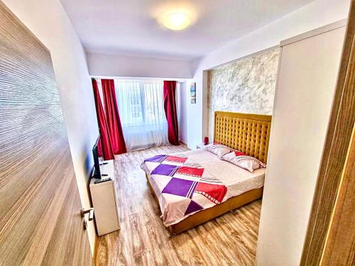 a bedroom with a bed and a red curtain at Summerland Seaview Apartments in Mamaia