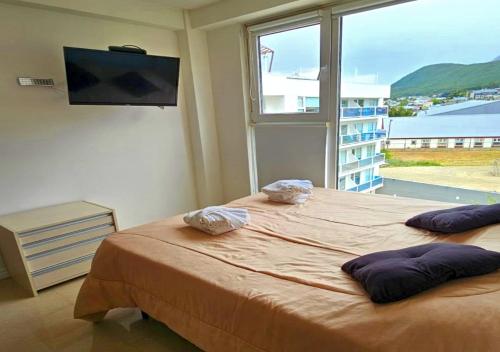 ウシュアイアにあるHappy Guest Apart 305の大きなベッドと大きな窓のある寝室