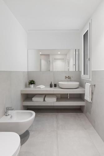 a white bathroom with two sinks and a mirror at Residence Conca Verde 1 with pool in Trarego Viggiona