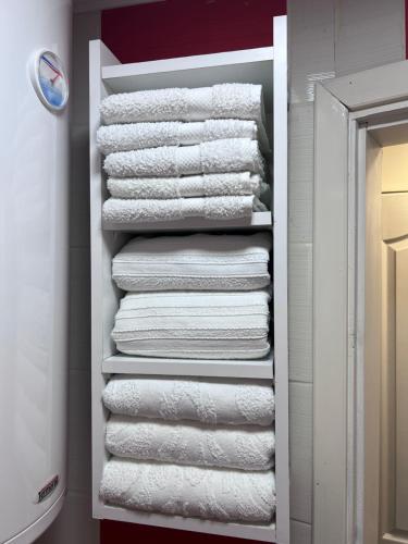 a closet with white towels on a shelf at Vikendica Martinović in Divčibare