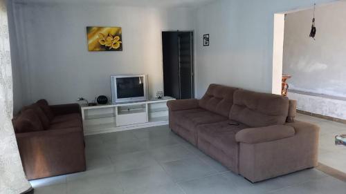 a living room with a couch and a tv at Chacara Condomínio Monte Verde Itu in Itu