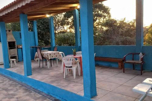 a patio with tables and chairs on a blue house at Chacara Condomínio Monte Verde Itu in Itu