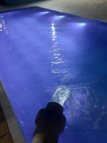 a person taking a picture of a pool of water at Chacara Condomínio Monte Verde Itu in Itu