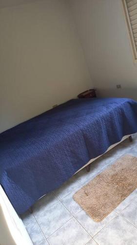 a blue bed with a blue blanket in a room at Chacara Condomínio Monte Verde Itu in Itu