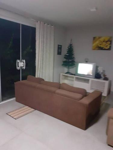a living room with a brown couch and a christmas tree at Chacara Condomínio Monte Verde Itu in Itu