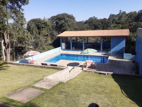 a swimming pool with two umbrellas in a yard at Chacara Condomínio Monte Verde Itu in Itu
