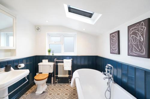 a bathroom with a tub and a toilet and a sink at Lux 3 Bed London House - Garden in London