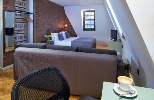 a hotel room with a bed and a couch with a table at London Paddington Apartments in London