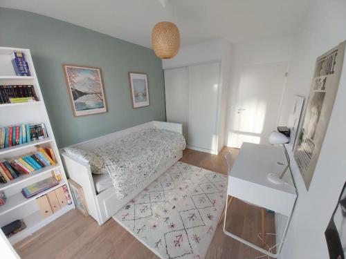 une petite chambre avec un lit et un bureau dans l'établissement Confort à Asnières, à Asnières-sur-Seine