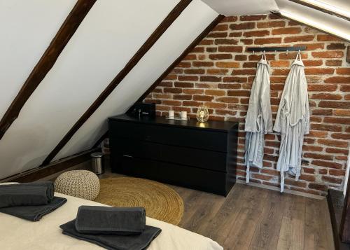a attic room with two beds and a brick wall at Golden Pinpoint in Gornje Vratno
