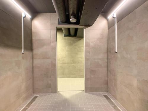 a bathroom with a shower with a tiled floor at Spåtind Fjellhotell in Nord Torpa