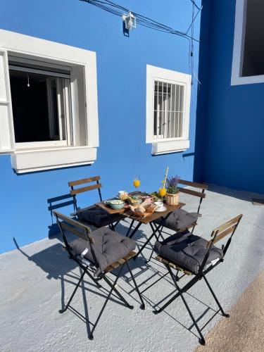 einen Tisch und Stühle in einem Zimmer mit blauer Wand in der Unterkunft Casita La Basseta d’ Oli in Villajoyosa