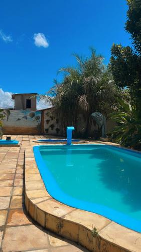 a blue swimming pool in a yard with trees at Chácara Tantan - Martins RN in Martins