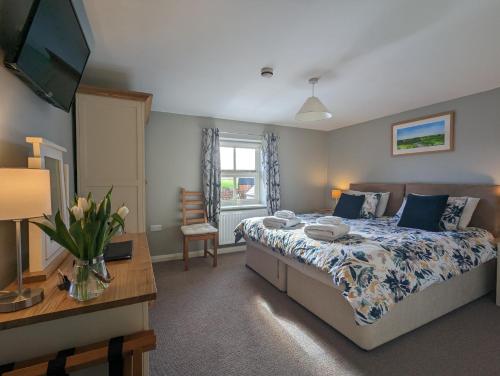 um quarto com uma cama, uma mesa e uma televisão em Wold Escapes, Highfield Farm em Great Driffield