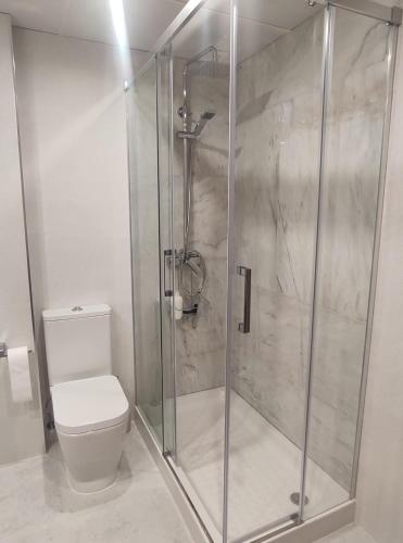 a bathroom with a glass shower with a toilet at Granada Home Center in Granada