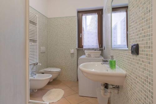 a bathroom with a sink and a toilet at Appartamento immerso nel verde - Ixihome in Casciago