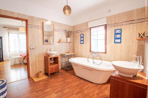 a large bathroom with a tub and a sink and a tub at LA VILLA BOLERO in Saint-Cyr-sur-Loire
