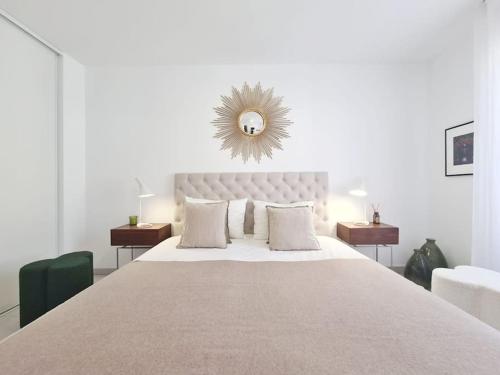 ein weißes Schlafzimmer mit einem großen Bett und einem Spiegel in der Unterkunft TLN-0011 - Magnifique appartement proche centre-ville in Six-Fours-les-Plages