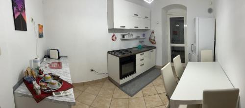 a kitchen with a stove and a table in it at Seal Home in Genova
