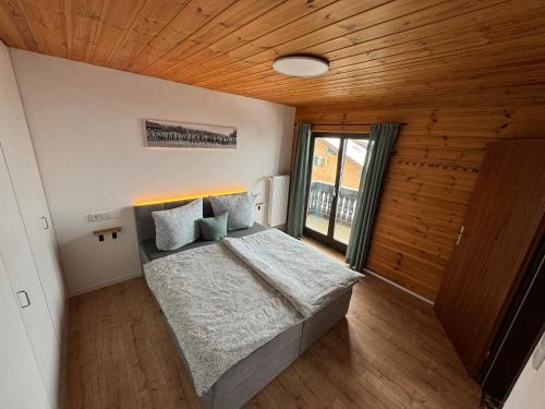 Schlafzimmer mit einem Bett mit Holzdecke in der Unterkunft Ferienwohnung Karo in Oberstaufen