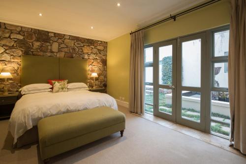 a bedroom with a bed and a stone wall at The Parkwood in Johannesburg