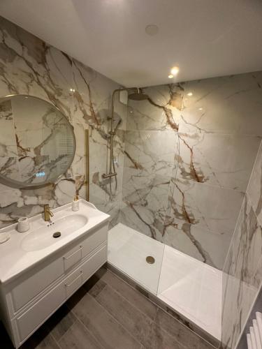 uma casa de banho com um lavatório branco e um espelho. em MarbleMood Spa em Obernai