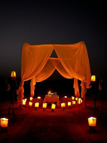 een tent met kaarsen en lichtjes in het donker bij Original Luxury Camp in Merzouga