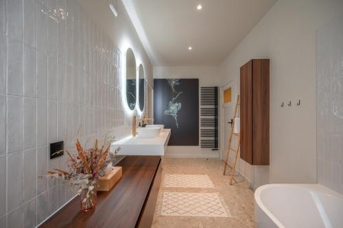 y baño con 2 lavabos, bañera y aseo. en Villa Cézar - big house at the center of Bruges - free parking, en Brujas
