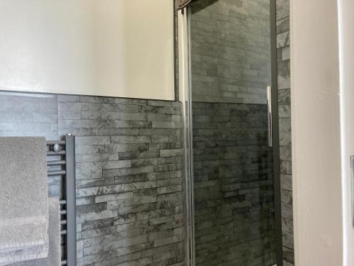 a shower with a glass door in a bathroom at Ashburnam Guest House in Hornsea