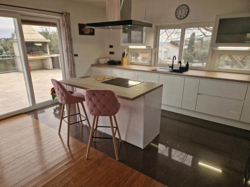 a kitchen with a island with two bar stools at Villa Vesna in Preko