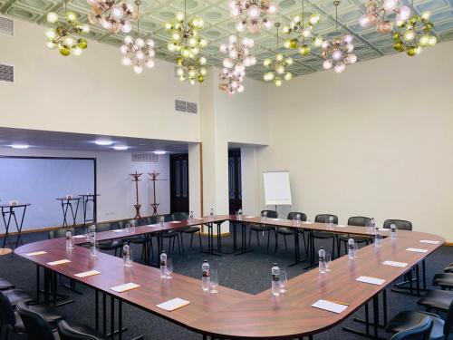 a large room with tables and chairs and chandeliers at Natsionalny Hotel in Kyiv
