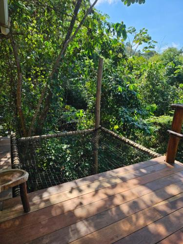 una terrazza in legno con panca e alberi di La Casa Del Mono a Minca