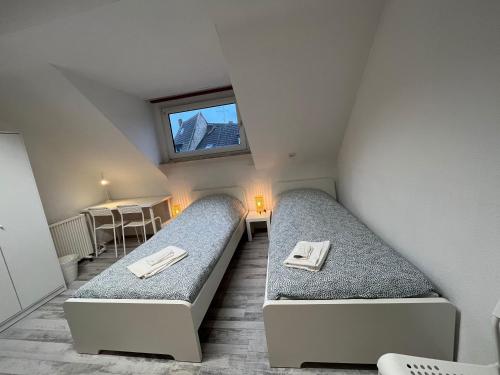 two beds in a small room with a window at Apartment R41 in Essen