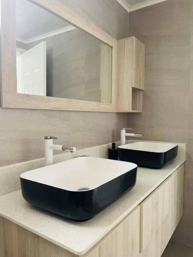 a bathroom with a black and white sink and a mirror at Meliyer cheerful 3 bedrooms villa at perebere in Pereybere