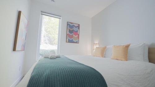 a bedroom with a bed with a green blanket on it at Chalet 24 - Modern peaceful retreat near Tremblant in La Conception
